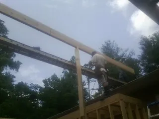 Carpenter setting a ridge beam over a new addition frame — Ice Dam Removal by Roofing Brothers in Pipersville
