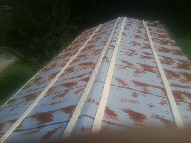 Rusted metal roof panels with new wood purlins before replacement — Storm Damage Roof Repair in Pipersville by Roofing Brothers