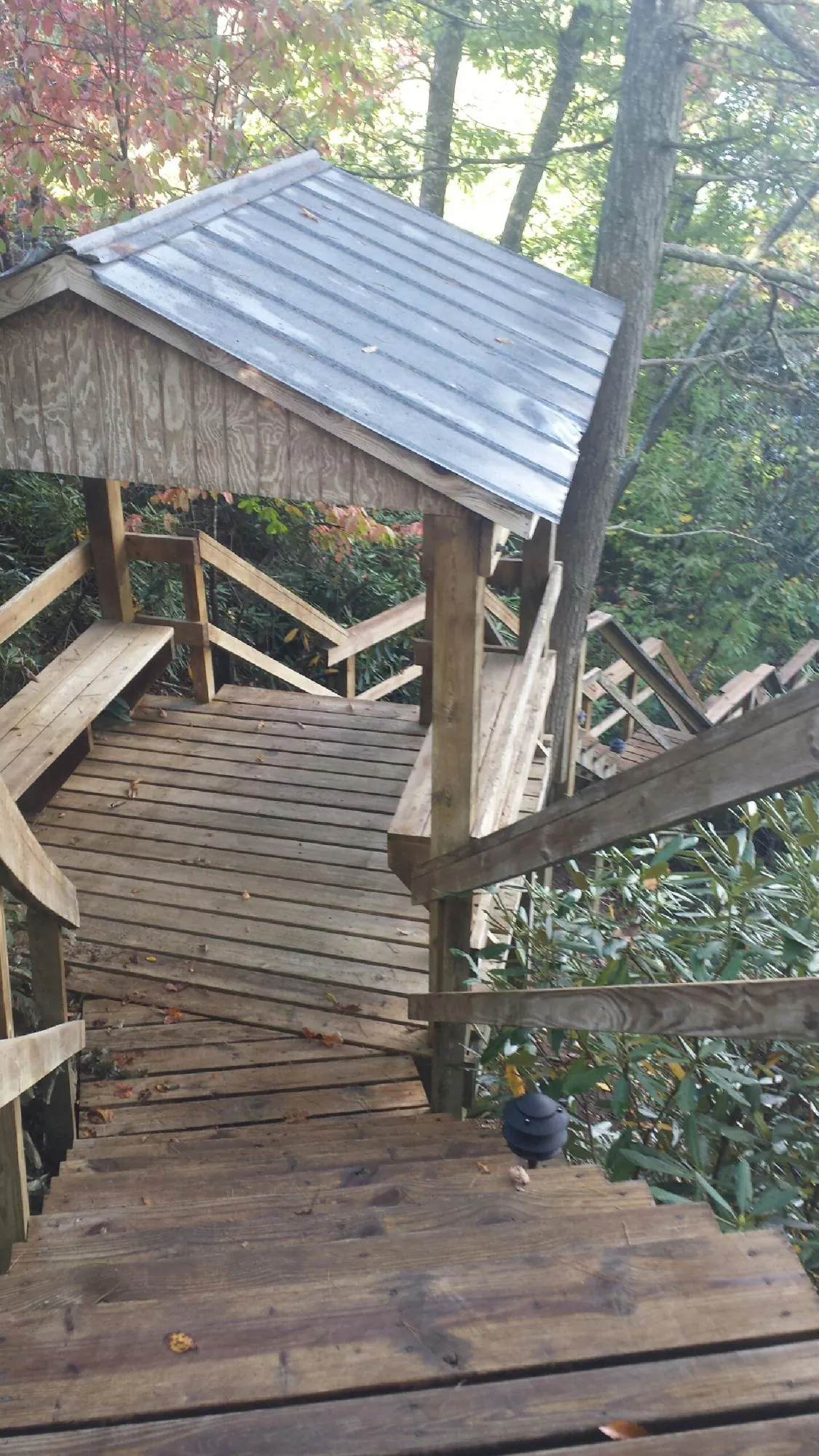 Metal roofed shelter over wooden steps on a wooded walkway — Skylight Repair & Installation work by our crew in Pipersville