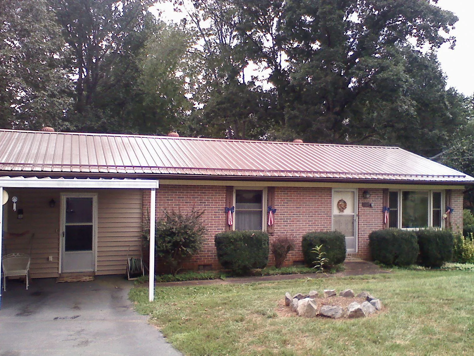 Bronze metal roof and carport on a brick ranch home — Roof Repair work by our crew in Pipersville