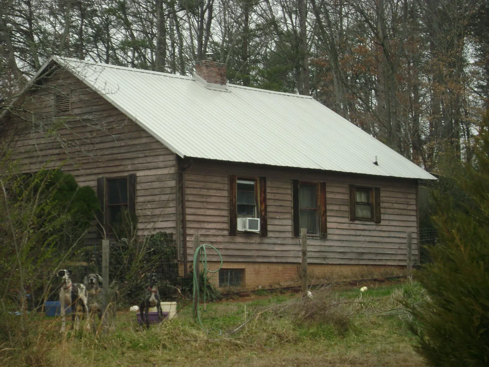 White metal roof on an old wood sided farmhouse, from a Metal Roof Installation job in Pipersville